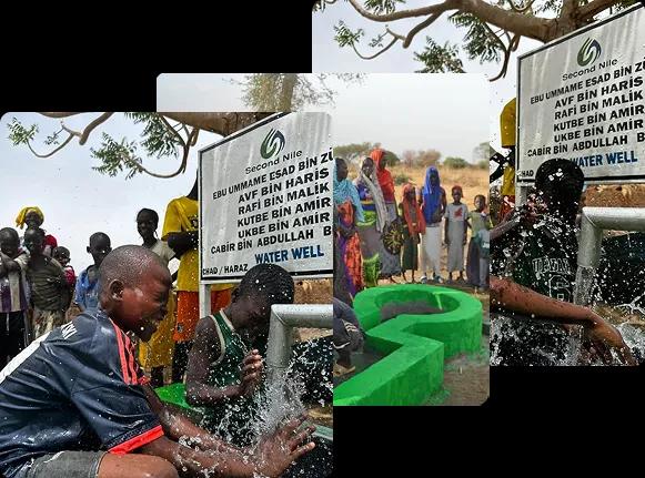 Children joyfully washing their hands and playing with water at a newly installed water well in an African village, surrounded by community members and a sign showing donor names.